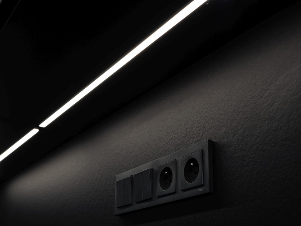 Ve dně horních skříněk je zabudováno LED osvětlení, v zádovém panelu jsou umístěny zásuvky.