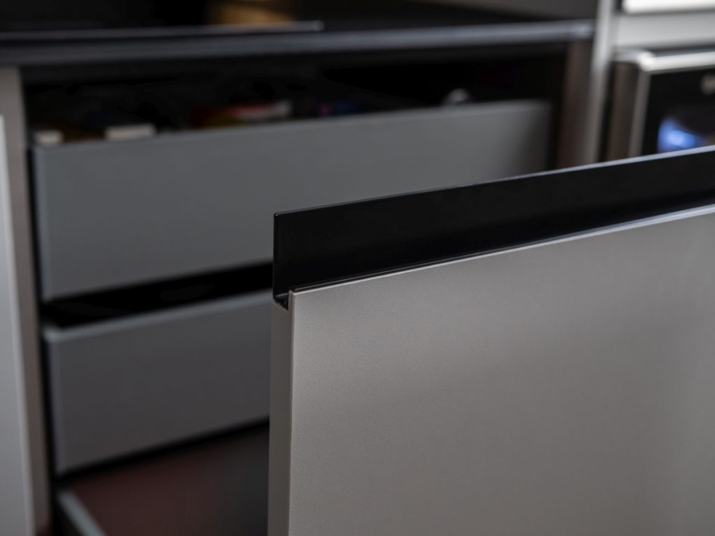 Jako madla jsou zde použity designové černé otvírací profily Linea Retta.
