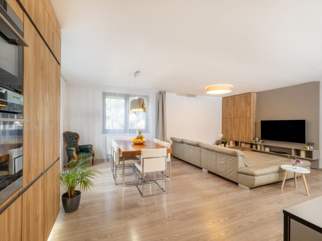 Oba materiály, Wood Hit v dekoru Císařský strom světlý a Silk Touch cappuccino, vytvářejí i televizní stěnu v obývací části pokoje. Místnost tak má jednotný design. 